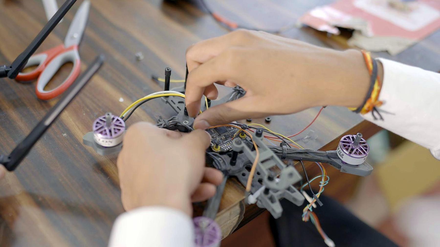 Hands assembling a drone frame