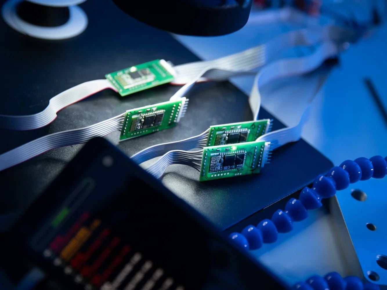 Circuit boards connected by ribbon cables on an electronics bench