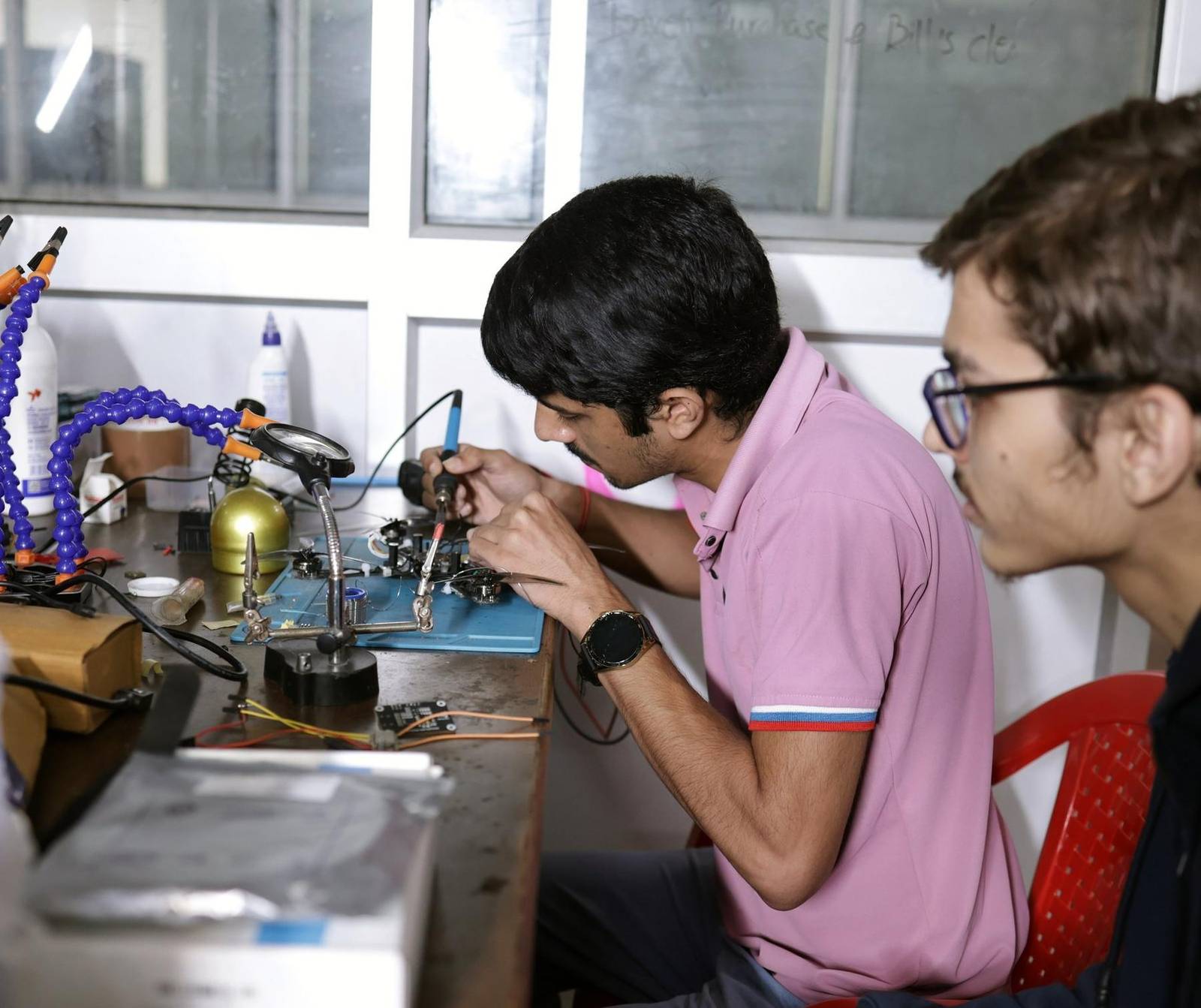 Students soldering electronics in a lab