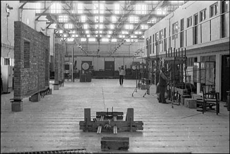 A large room with a few people working

AI-generated content may be incorrect.