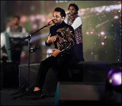 A person sitting on a stage with a microphone

AI-generated content may be incorrect.